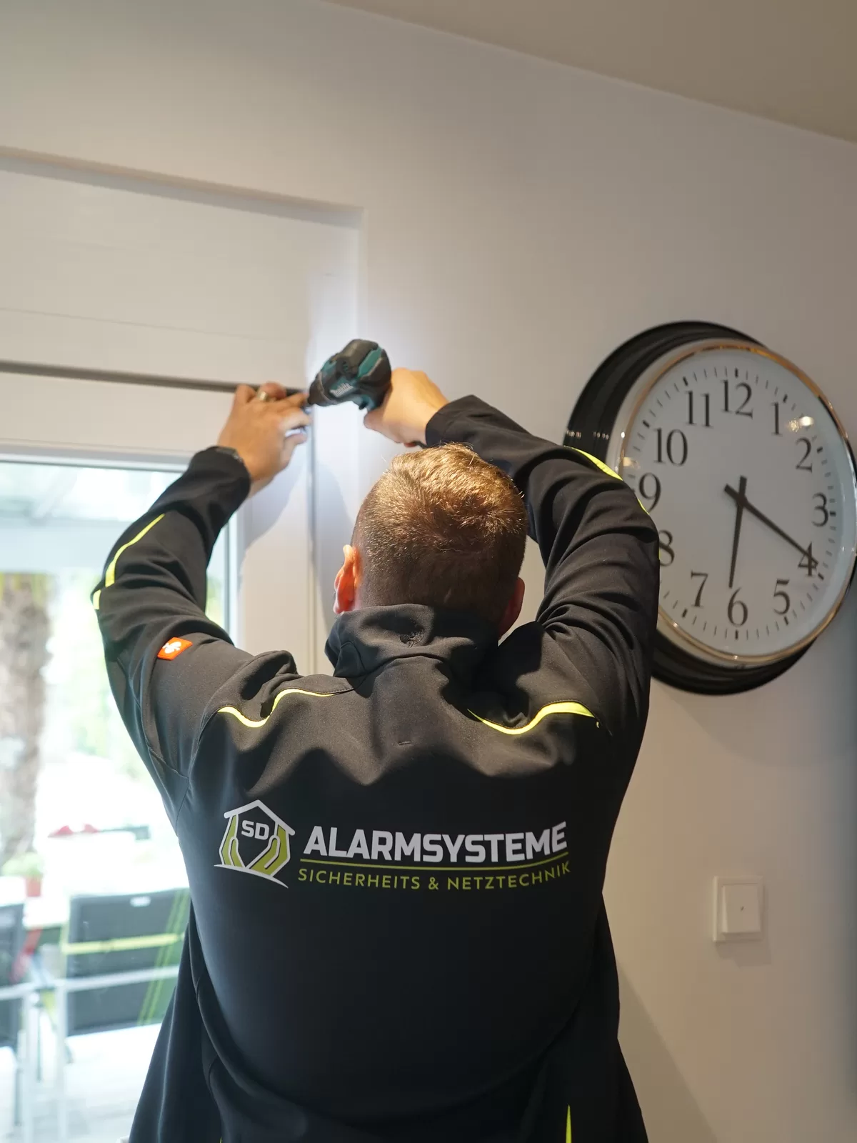 Fachkraft von SD Alarmsysteme bei einer Montage im Eingangsbereich