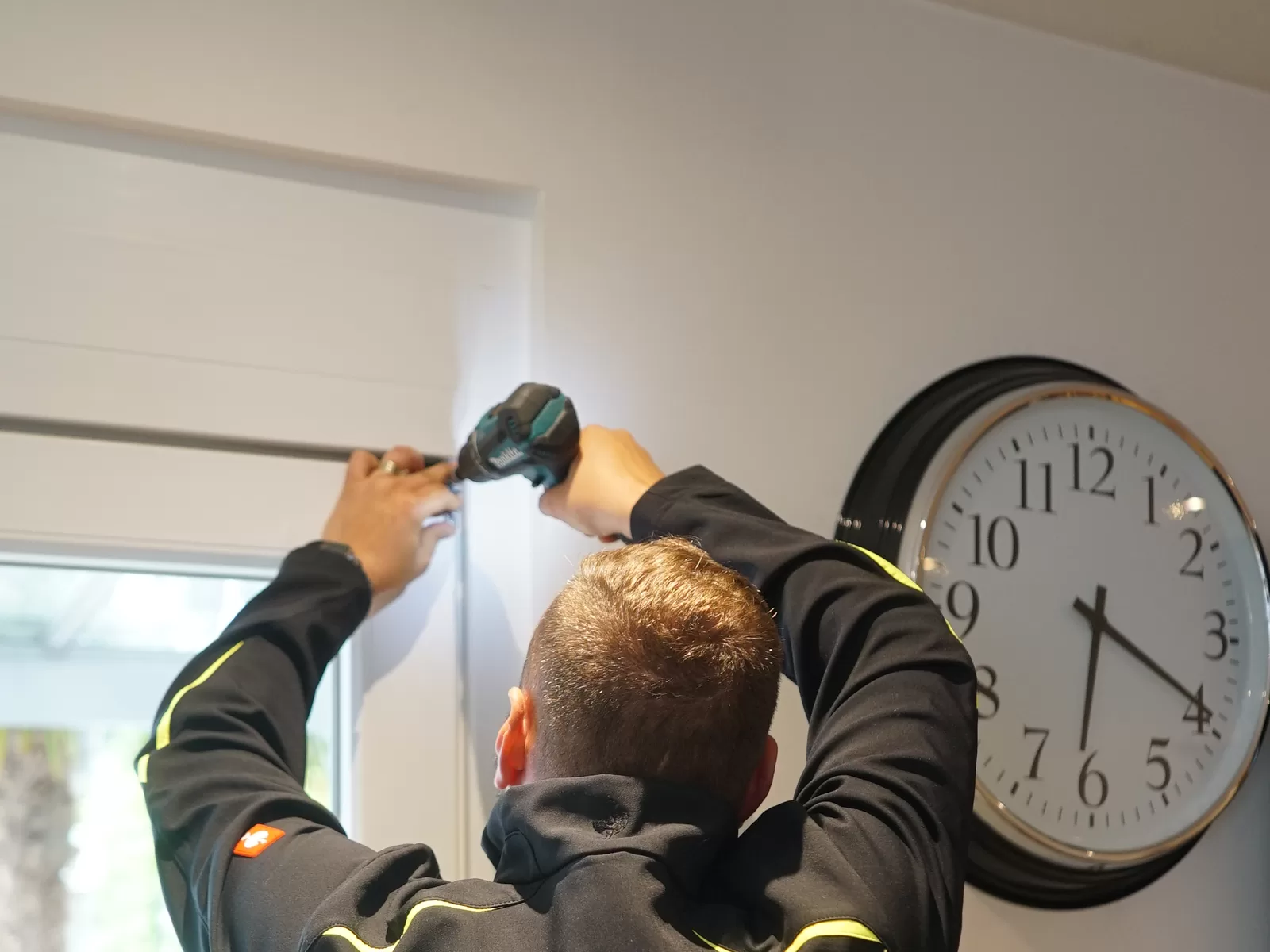 Fachkraft von SD Alarmsysteme bei einer Montage oberhalb einer Tür